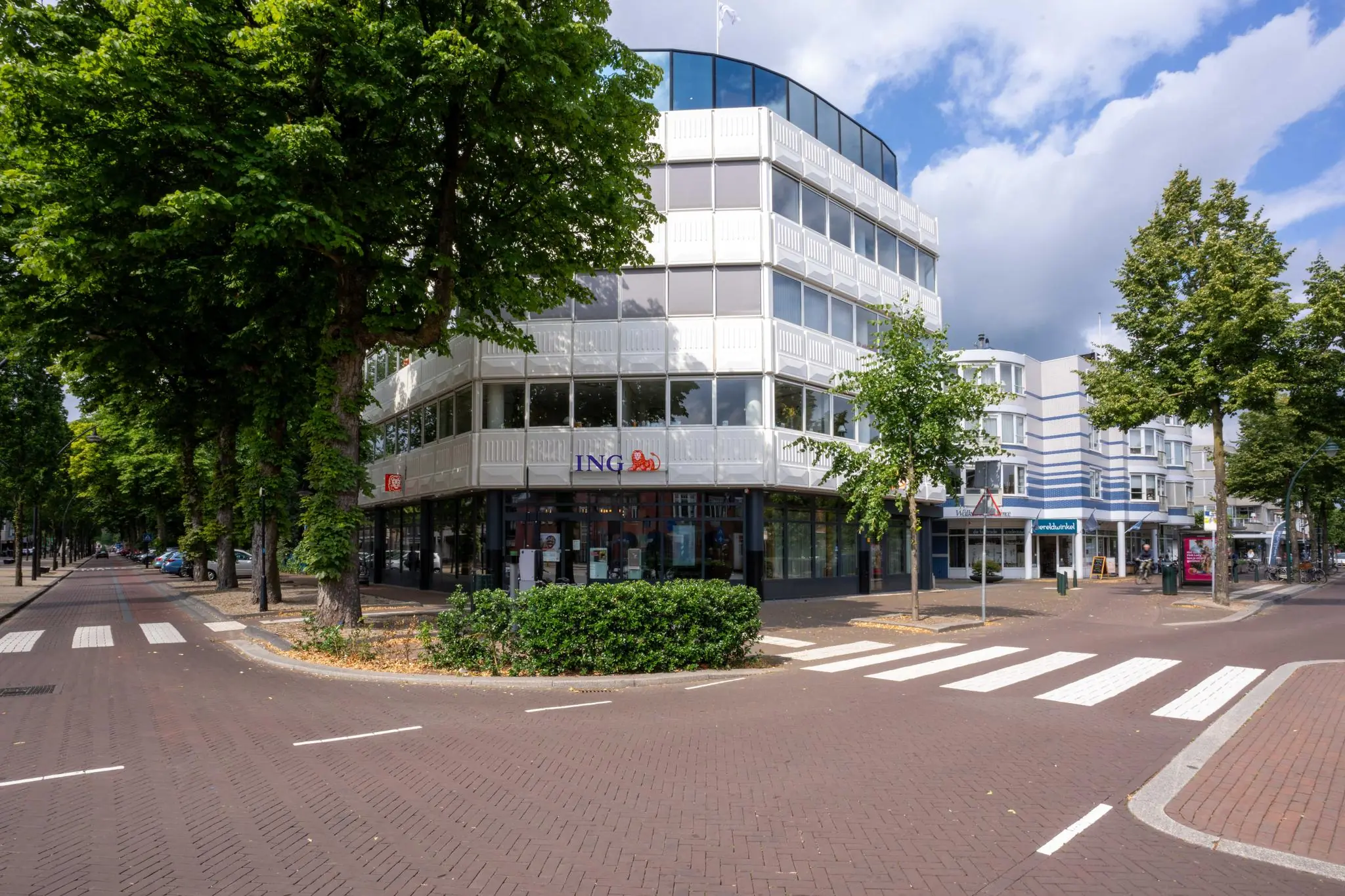 Wit kantoorpand op de hoek van de 1e Hogeweg met op de begane grond een ING-bankfiliaal.